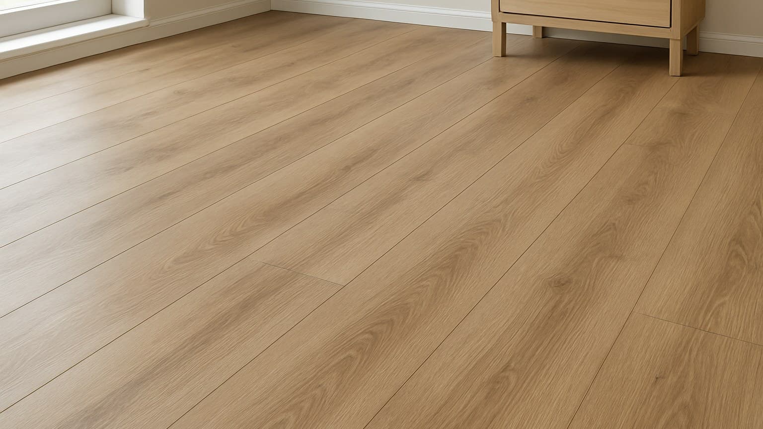 Light tan-wood-toned manufactured flooring planks with visible seams installed in a room with white trim and furniture