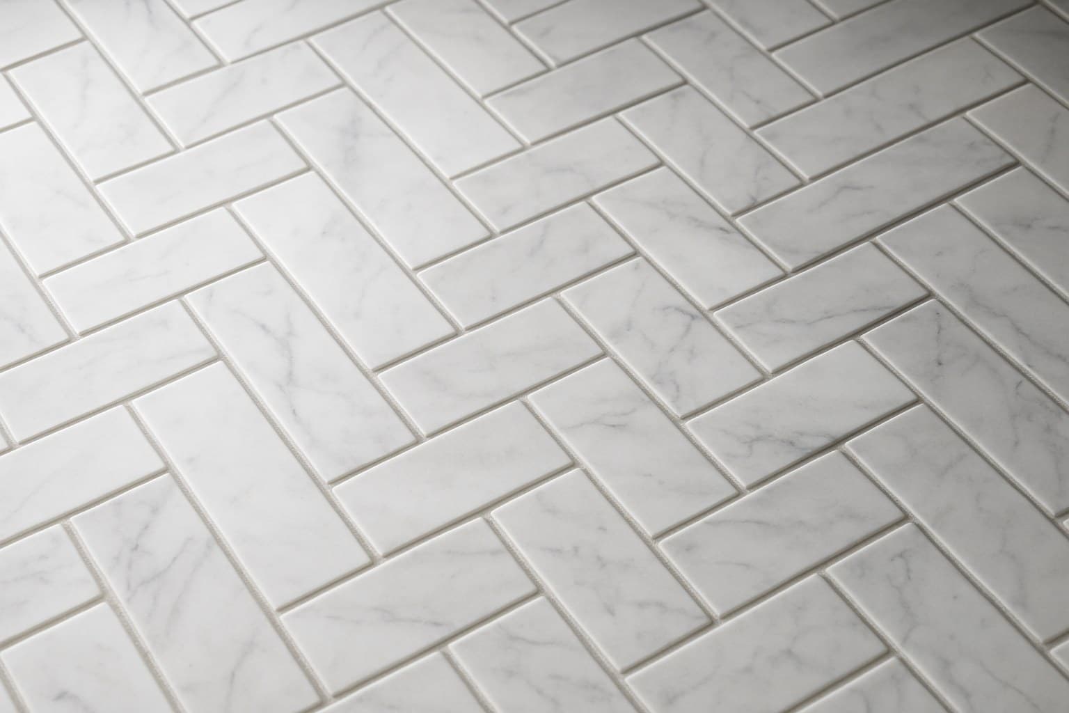 Carrara marble tile with soft grey veining on a white background