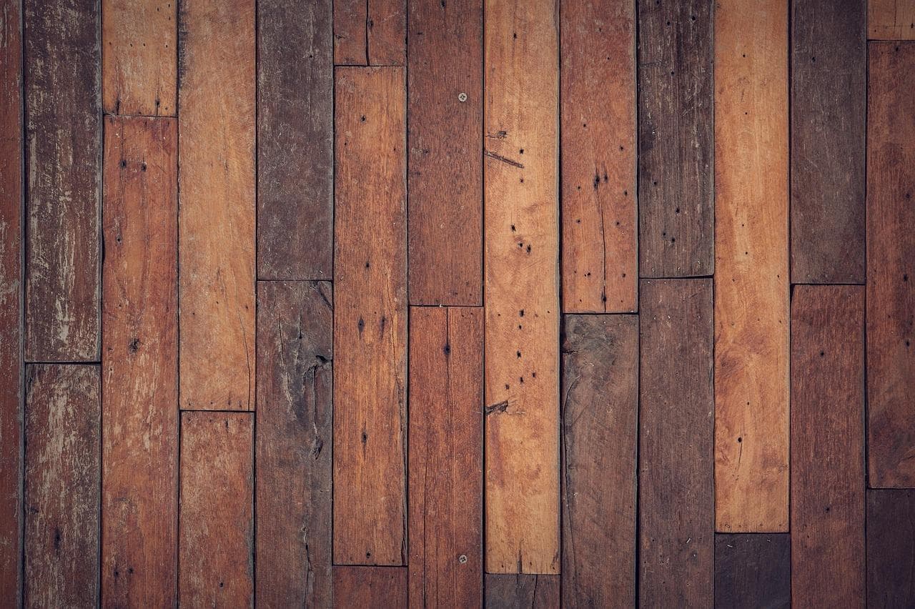 Dark wooden planks with crisp dark lines separating each plank in a random-width layout.