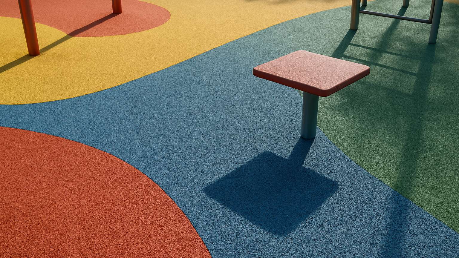 A playground floor with colored rubber safety surface in distinct zones (blue, yellow, red, green) and playground equipment visible.