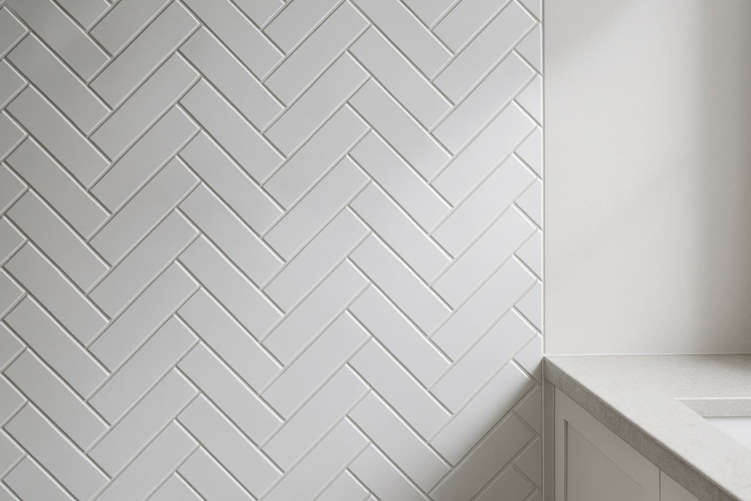 Subway tile laid in a herringbone pattern on a wall