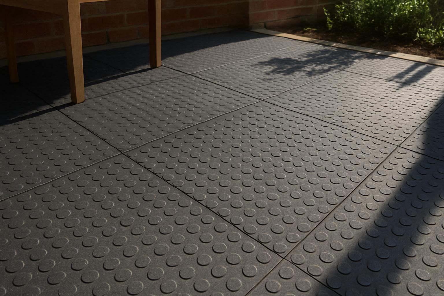 Rubber tile flooring on a patio in direct bright sunlight