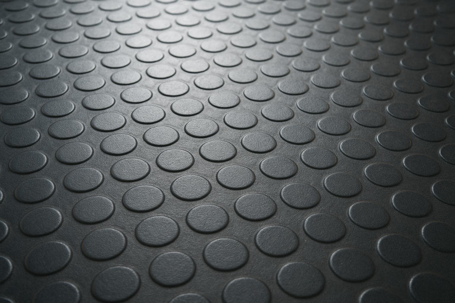 Close-up of raised coin-pattern studs on rubber coin flooring designed for traction.