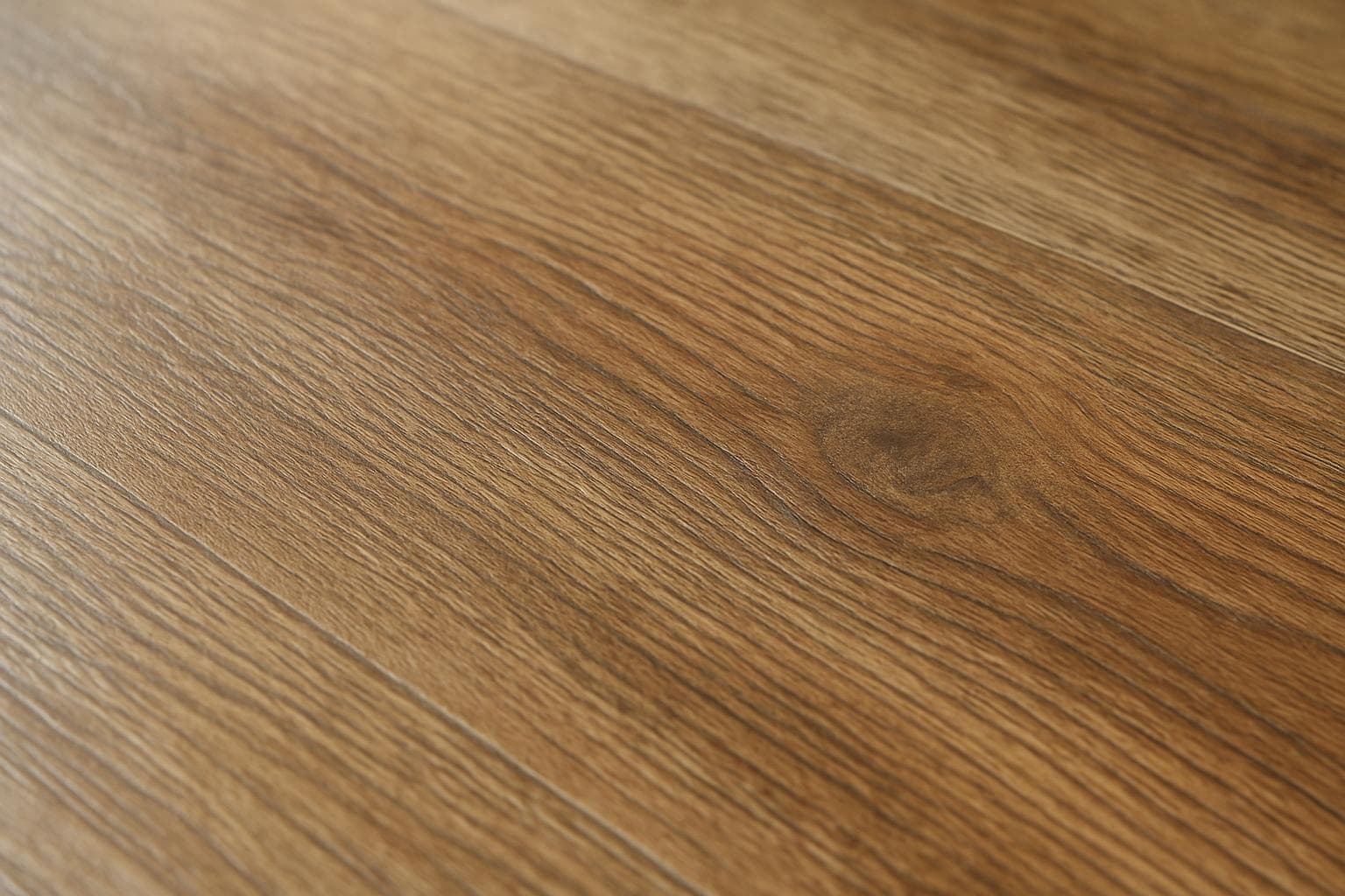 Close-up of a vinyl plank's textured wear layer and wood grain print